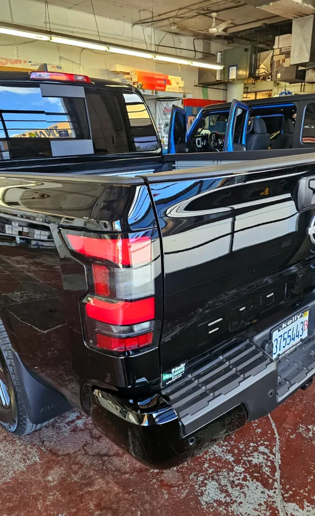 Black pickup truck with a deep gloss finish in the MLUX shop
