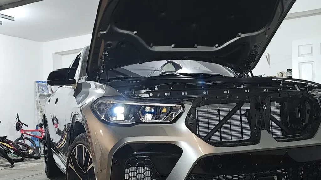 Pre-purchase inspection on a BMW X5 M with the hood open for engine diagnostics