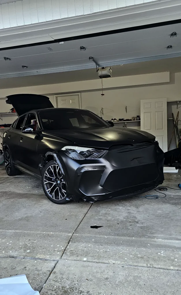 BMW X6 receiving a matte black vinyl wrap