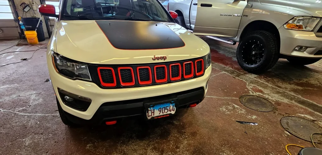 Jeep Compass with a black hood decal and red grille inserts