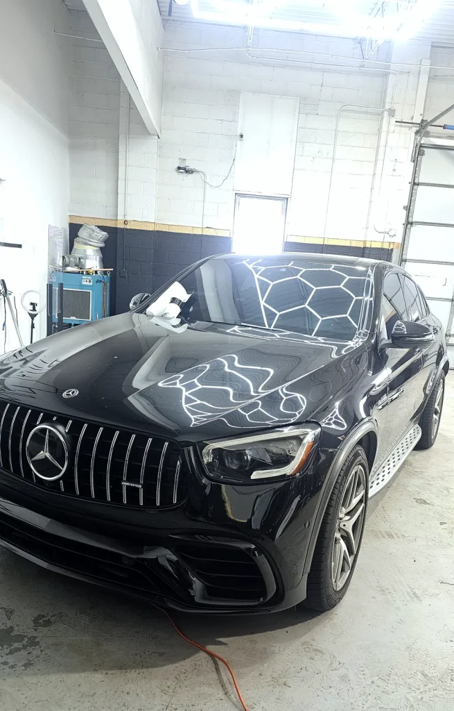 Black Mercedes-AMG GLC reflecting the hexagon LED ceiling lights