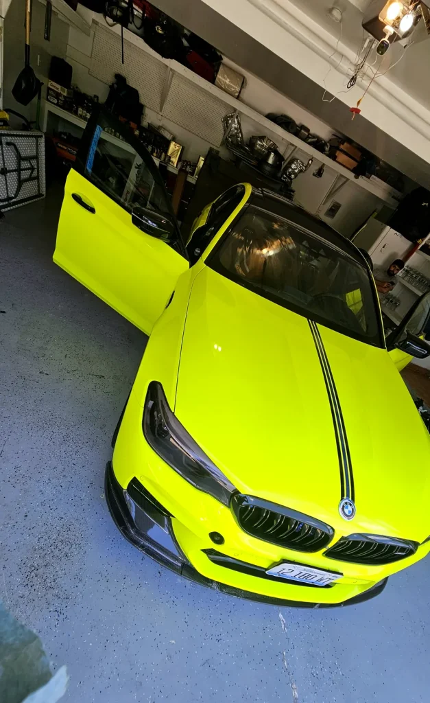 BMW in a fluorescent yellow wrap with a black racing stripe