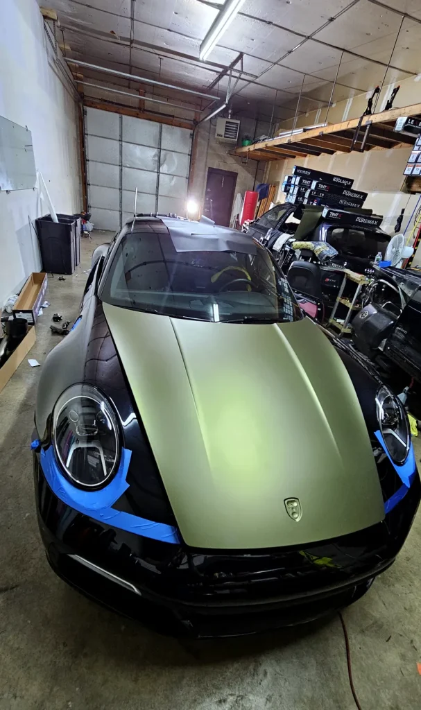 Satin green wrap film being applied to a Porsche hood