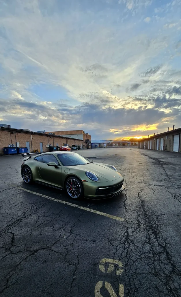 Satin green Porsche 911 color-change wrap at sunset