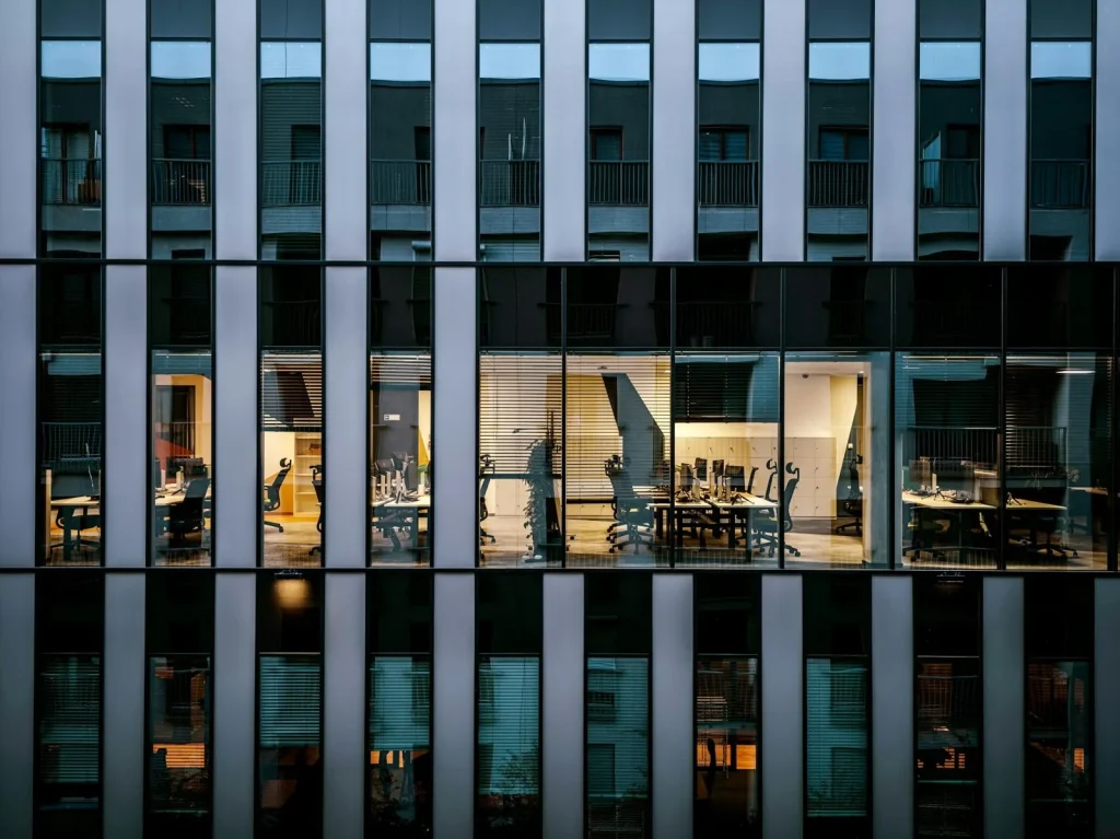 Glass office facade with workspaces visible through tinted windows